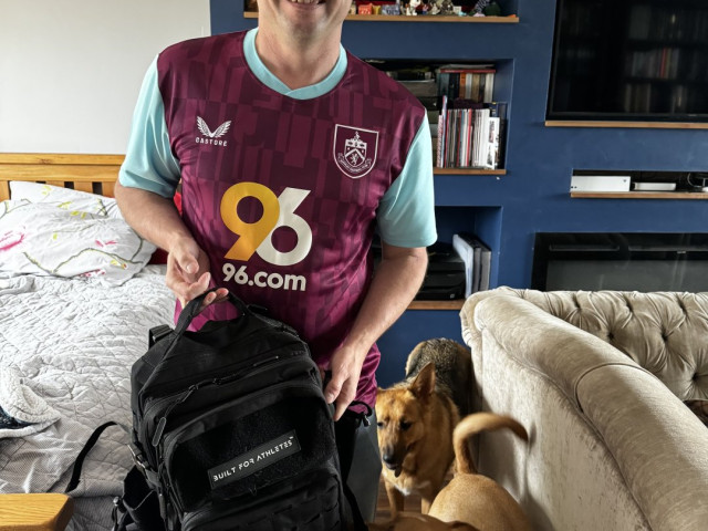 Man in Burnley football shirt leaving house with podencos behind