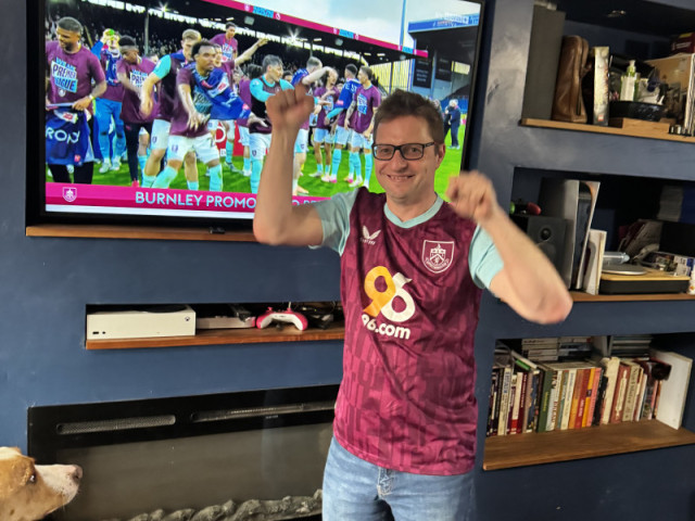 Photo of me wearing a Burnley home shirt in front of the Bob Lord Stand on TV