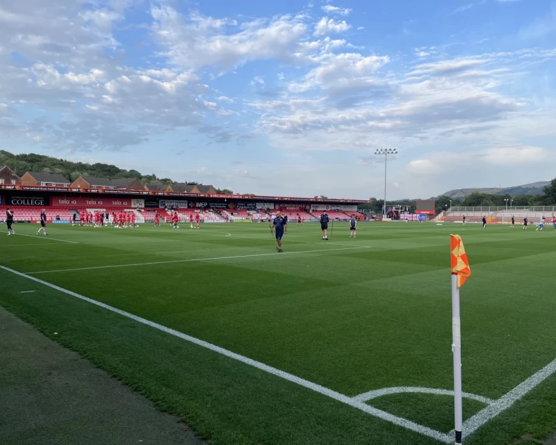 Picture looking across the pitch before kickoff at the Wham Stadium, with blue skies and white clouds above