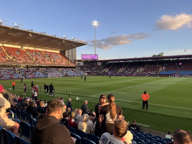 Turf Moor stadium under the floodlights on a sunny evening
